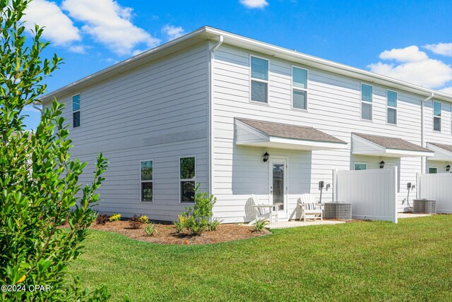 back of property featuring central air condition unit, a patio area, and a lawn