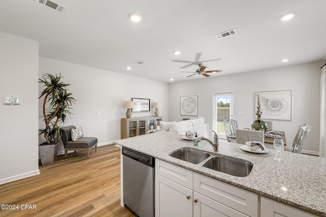 kitchen featuring white cabinets, dishwasher, light stone countertops, and sink