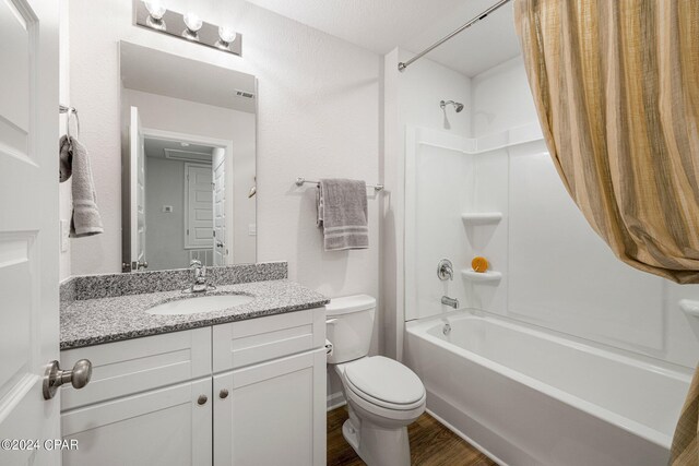 full bathroom featuring hardwood / wood-style flooring, vanity, shower / bathtub combination, and toilet