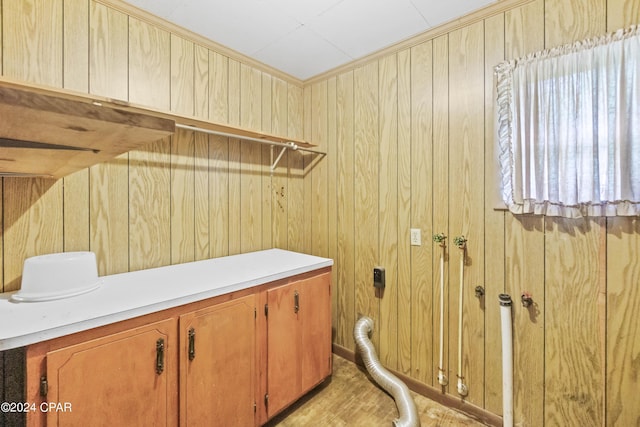 washroom featuring wooden walls and cabinets