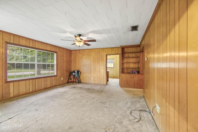 carpeted spare room with ceiling fan and built in features