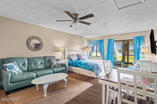 bedroom featuring a textured ceiling, access to outside, dark wood-style flooring, and a ceiling fan