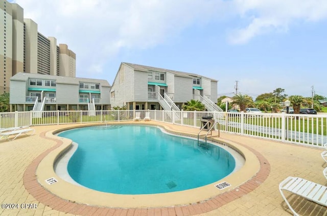 community pool featuring fence and a patio