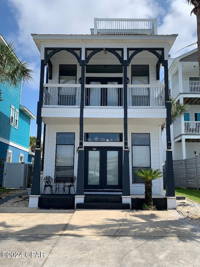 view of front facade with a balcony and french doors