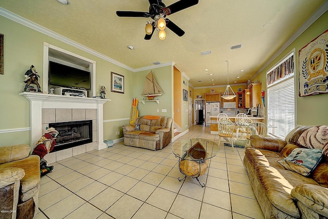 living room with a tile fireplace, light tile patterned floors, ceiling fan, and crown molding