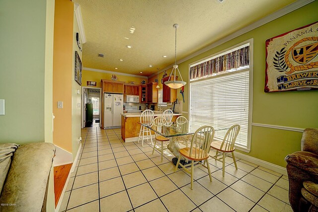 tiled dining space with a textured ceiling and crown molding