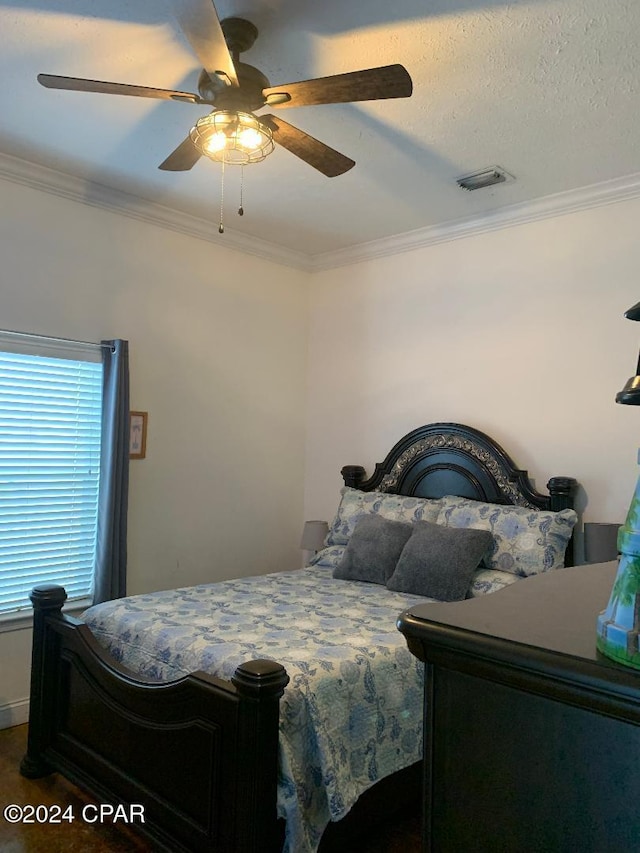 bedroom with ceiling fan, a textured ceiling, and ornamental molding