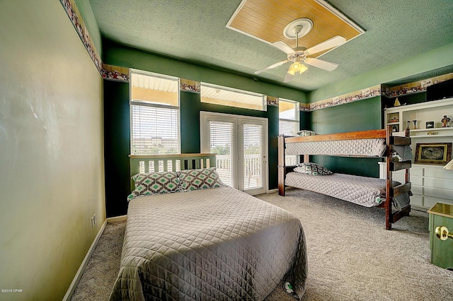 carpeted bedroom featuring ceiling fan and a textured ceiling