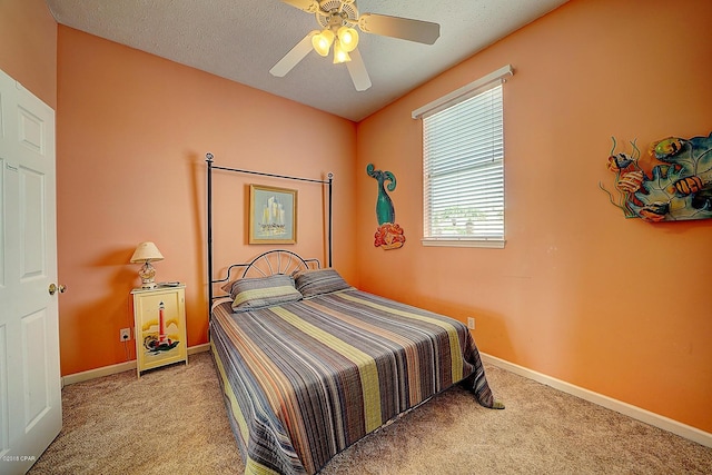 bedroom featuring light carpet, a textured ceiling, and ceiling fan