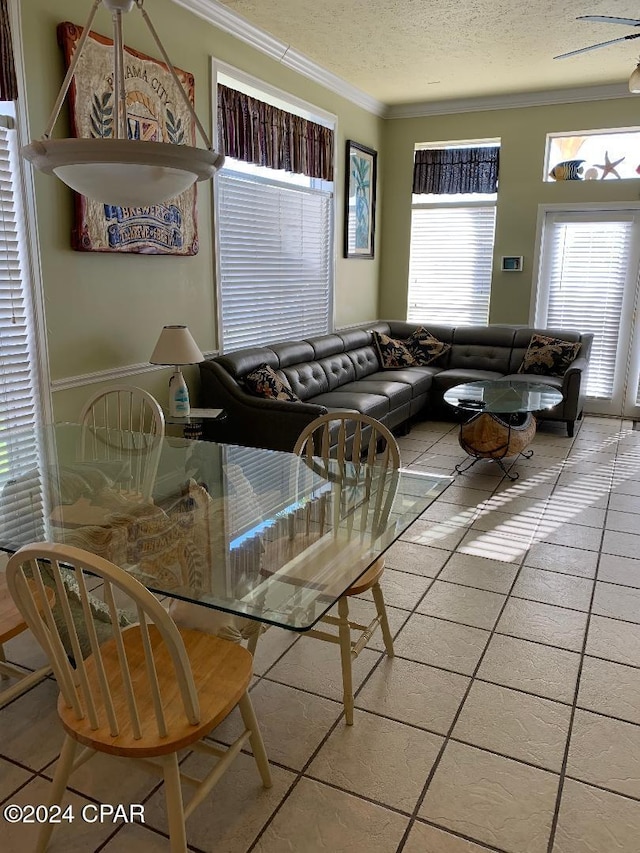 tiled dining area featuring a textured ceiling, ceiling fan, and crown molding