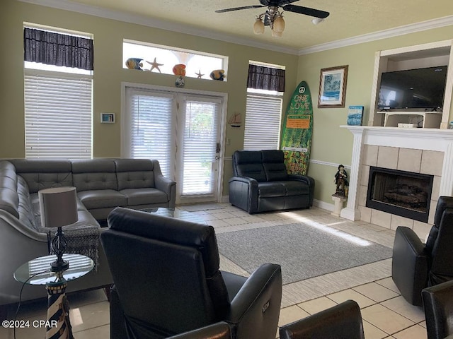 tiled living room with a tile fireplace, a textured ceiling, ceiling fan, and ornamental molding