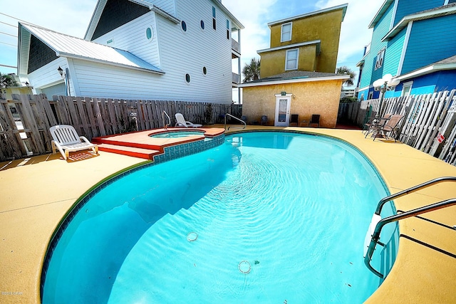 view of swimming pool featuring an in ground hot tub