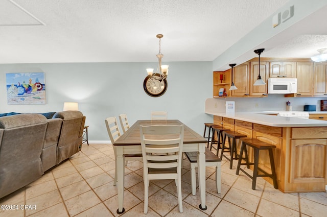 tiled dining area with a notable chandelier and a textured ceiling