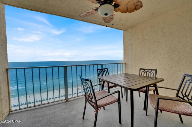 balcony with a water view and ceiling fan