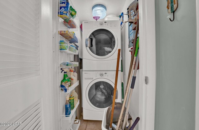 laundry room with stacked washer / dryer and tile patterned floors