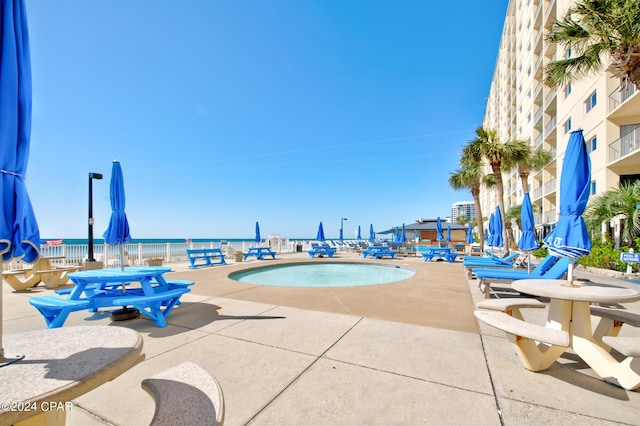 view of swimming pool with a patio and a water view