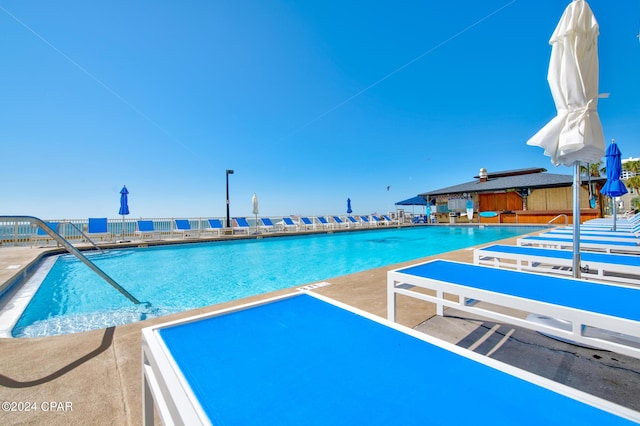 view of swimming pool featuring a patio and a water view