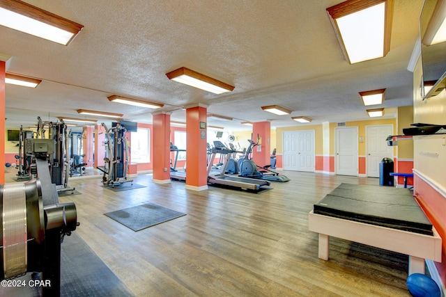 exercise room featuring hardwood / wood-style flooring and a textured ceiling