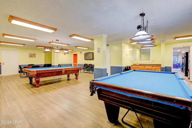 recreation room with a textured ceiling, ornamental molding, and billiards