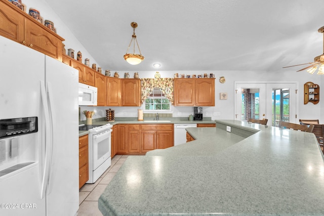 kitchen featuring a healthy amount of sunlight, sink, white appliances, and decorative light fixtures