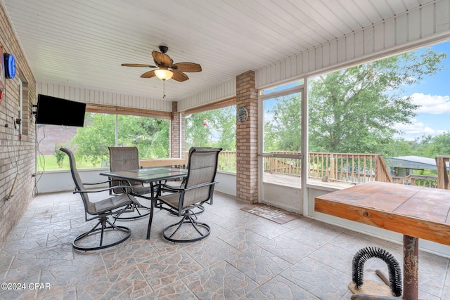 sunroom / solarium with plenty of natural light and ceiling fan