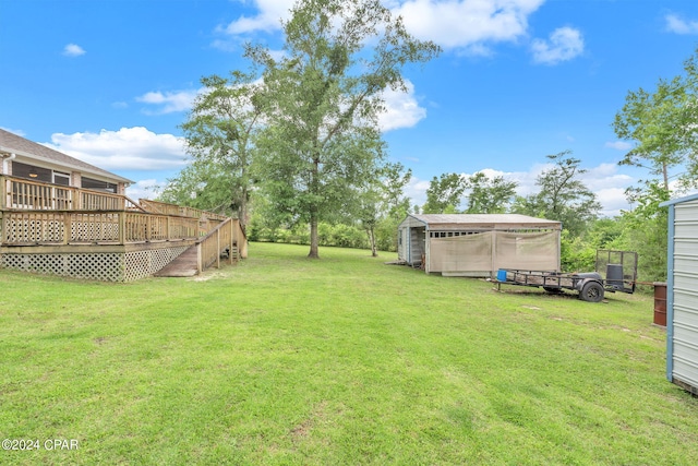 view of yard featuring a wooden deck and a storage shed