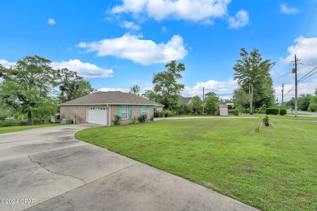 view of front of house featuring a garage, a front lawn, and central air condition unit