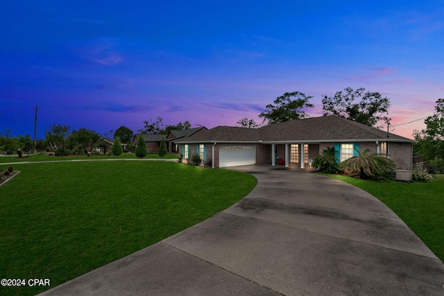 ranch-style home with a garage and a lawn