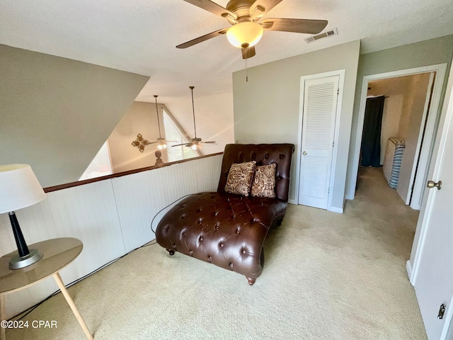 sitting room featuring vaulted ceiling, ceiling fan, and light colored carpet