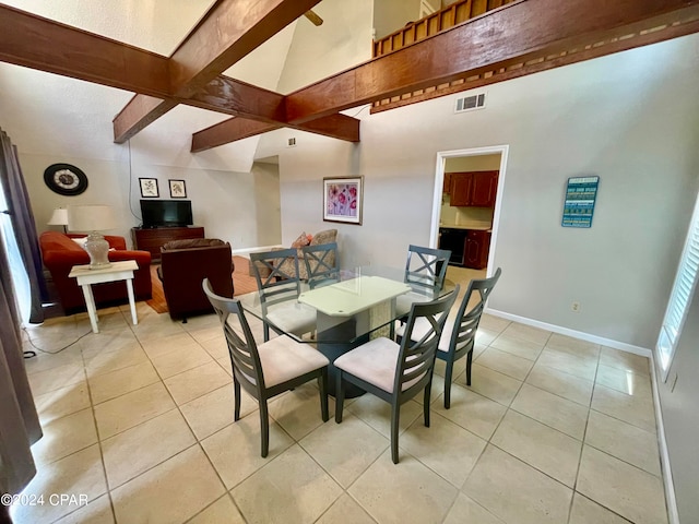 dining area with vaulted ceiling with beams and light tile patterned flooring