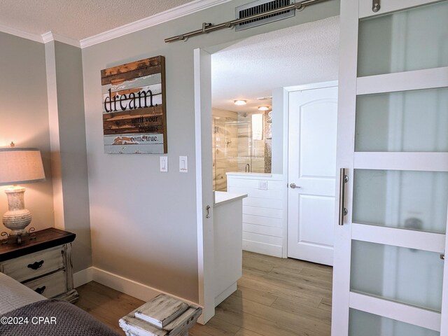 bedroom featuring hardwood / wood-style flooring, a textured ceiling, and crown molding