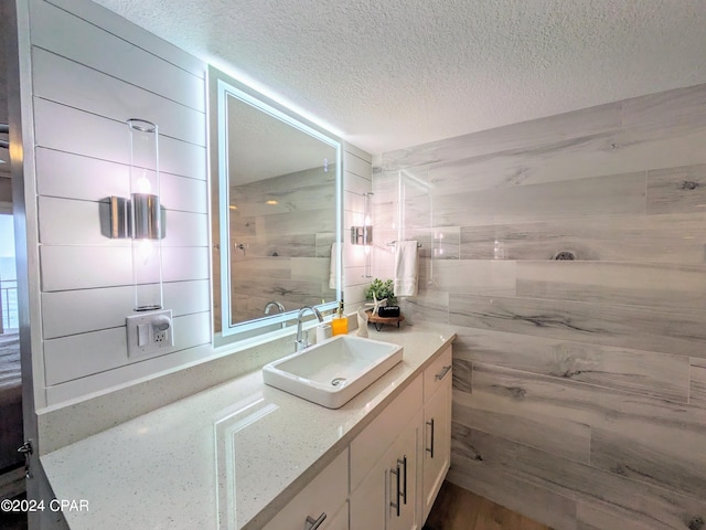 bathroom featuring a textured ceiling and oversized vanity