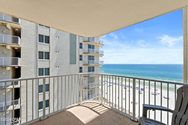 balcony with a water view and a view of the beach