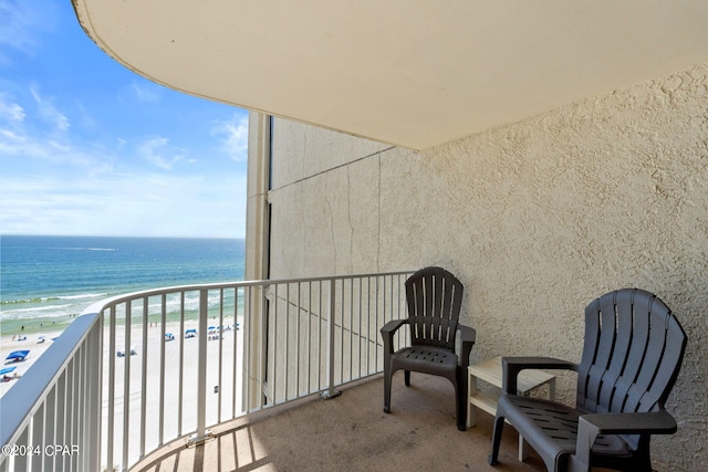 balcony featuring a view of the beach and a water view