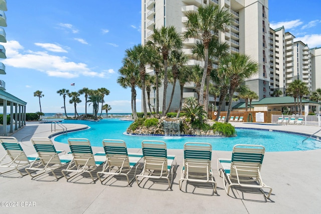 view of swimming pool with pool water feature and a patio