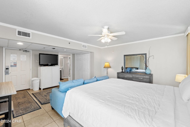 bedroom with a textured ceiling, ceiling fan, light tile patterned floors, and crown molding