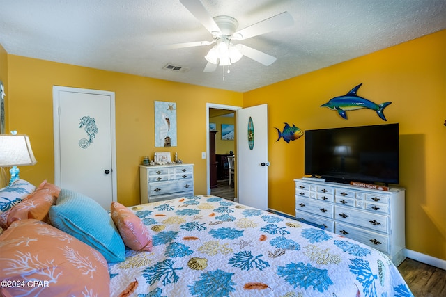 bedroom featuring a textured ceiling, dark hardwood / wood-style floors, and ceiling fan