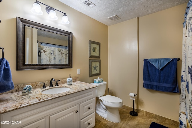 bathroom with tile floors, a textured ceiling, oversized vanity, and toilet