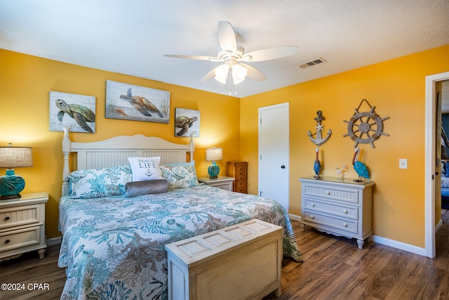 bedroom featuring ceiling fan, a textured ceiling, and dark wood-type flooring