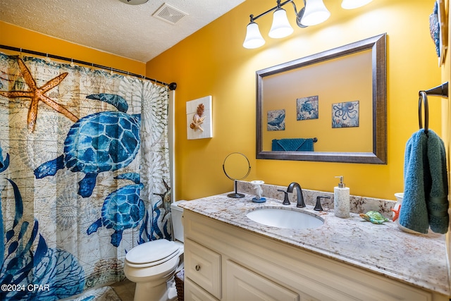 bathroom featuring tile floors, a textured ceiling, toilet, and vanity with extensive cabinet space