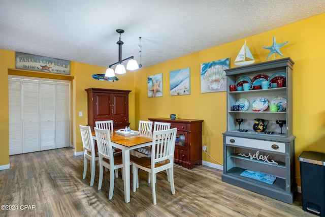 dining space featuring a textured ceiling and hardwood / wood-style floors