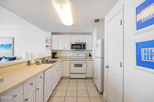 kitchen with white appliances, white cabinets, sink, and light tile flooring