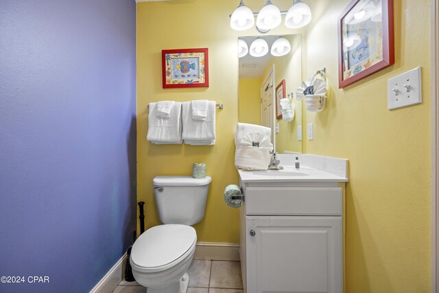 bathroom featuring tile flooring, toilet, and vanity with extensive cabinet space