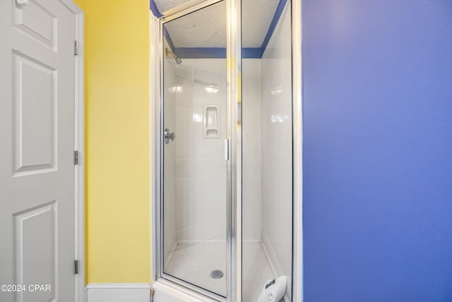 bathroom featuring walk in shower and a textured ceiling