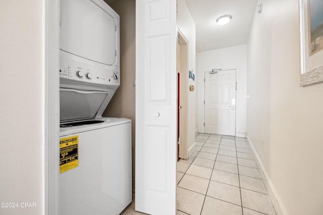 laundry area with stacked washer and dryer and light tile flooring