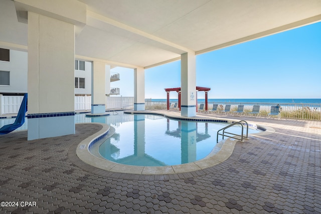 view of pool featuring a patio area and a water view