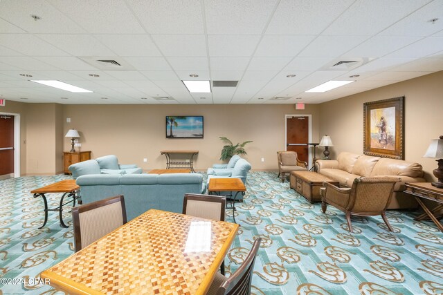 living room with carpet flooring and a drop ceiling