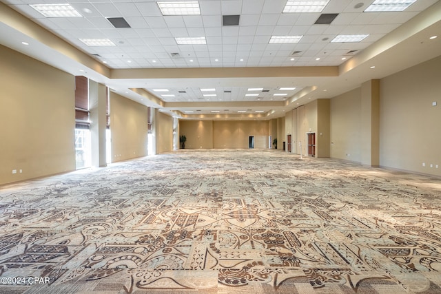 unfurnished room featuring a high ceiling, a paneled ceiling, and a raised ceiling