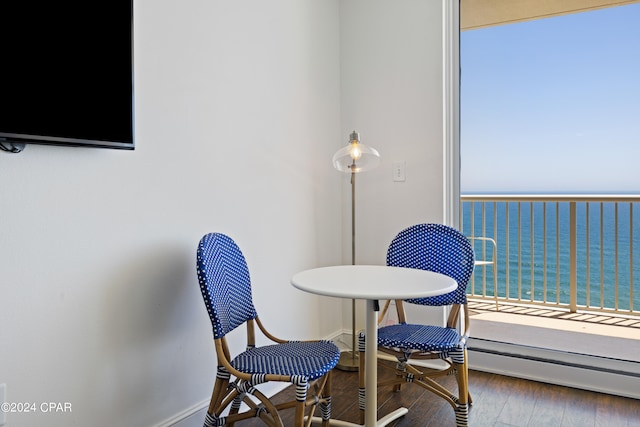 sitting room featuring a water view, a baseboard radiator, and hardwood / wood-style flooring