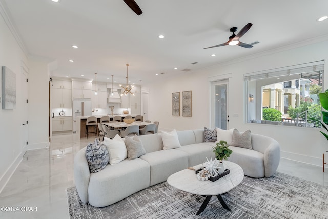 living room with ceiling fan with notable chandelier and ornamental molding